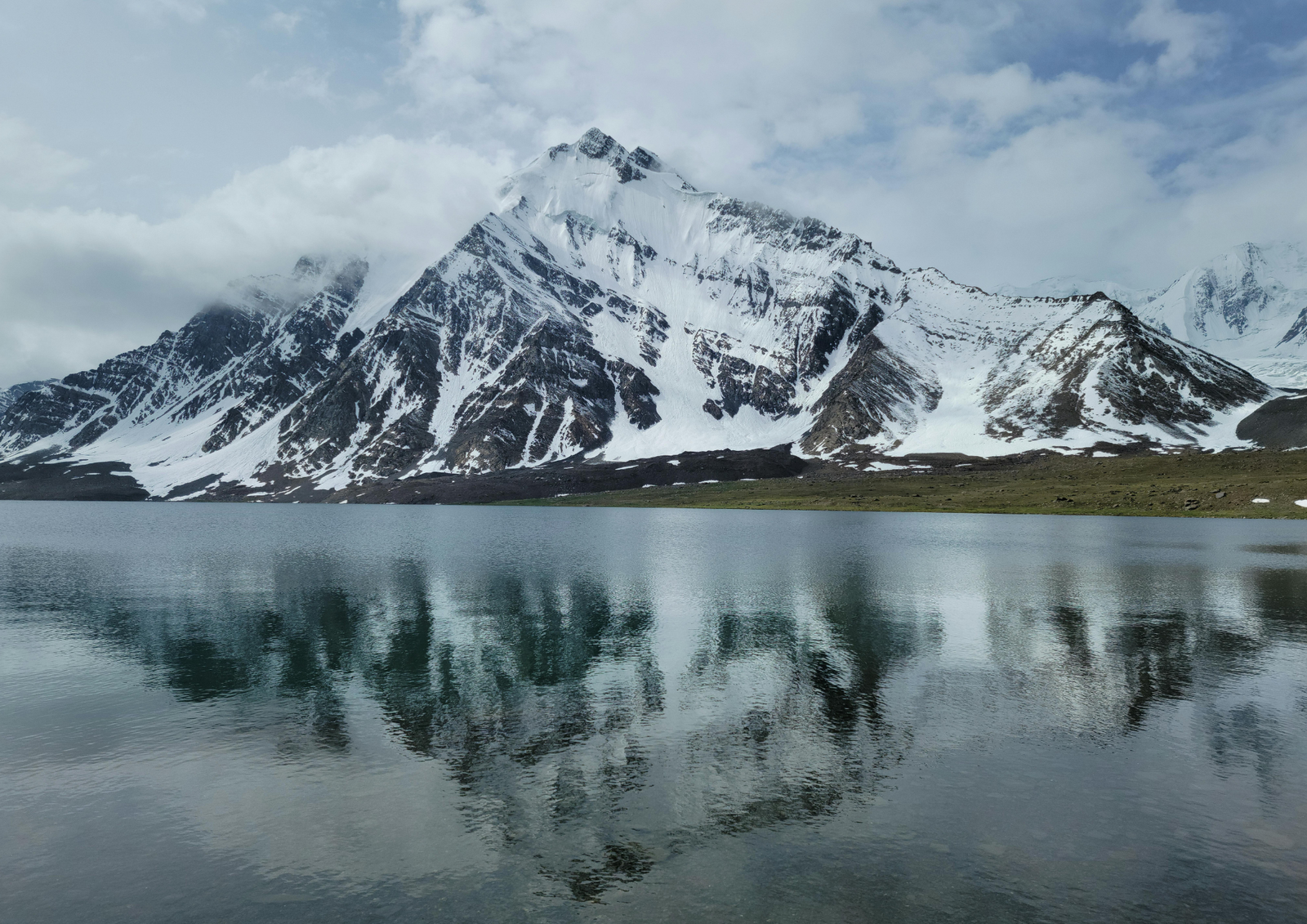 Jagged rock peaks with a dusting of snow under a clear turquoise sky